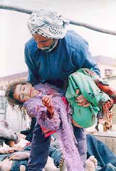 A father carrying his daughter felled by U.S. bombs in Basra