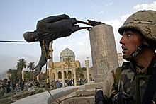 A U.S. soldier watches as a statue of Iraq's President Saddam Hussein falls