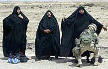 A US female soldier frisks an Iraqi woman