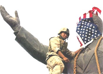 A US marine covering  the face of a statue of President Saddam Hussain